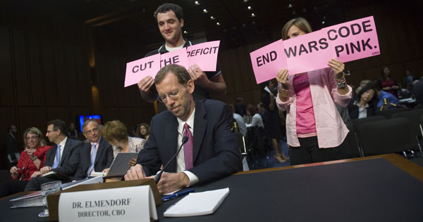 Code Pink protests behind CBO head Douglas Elmendorf