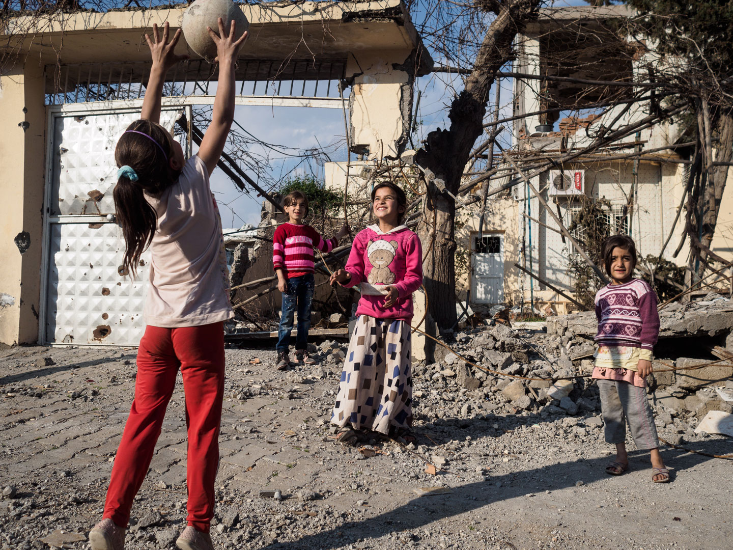 Children playing in front of their damaged house in Cizre.