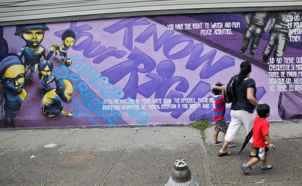 pemA-woman-and-children-walk-past-a-street-mural-in-New-York.-APBebeto-Matthewemp