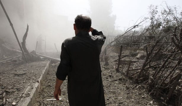 A-man-inspects-a-site-hit-by-what-activists-said-were-missiles-fired-by-Syrian-Air-Force-fighter-jets-loyal-to-President-Bashar-al-Assad.-Reuters