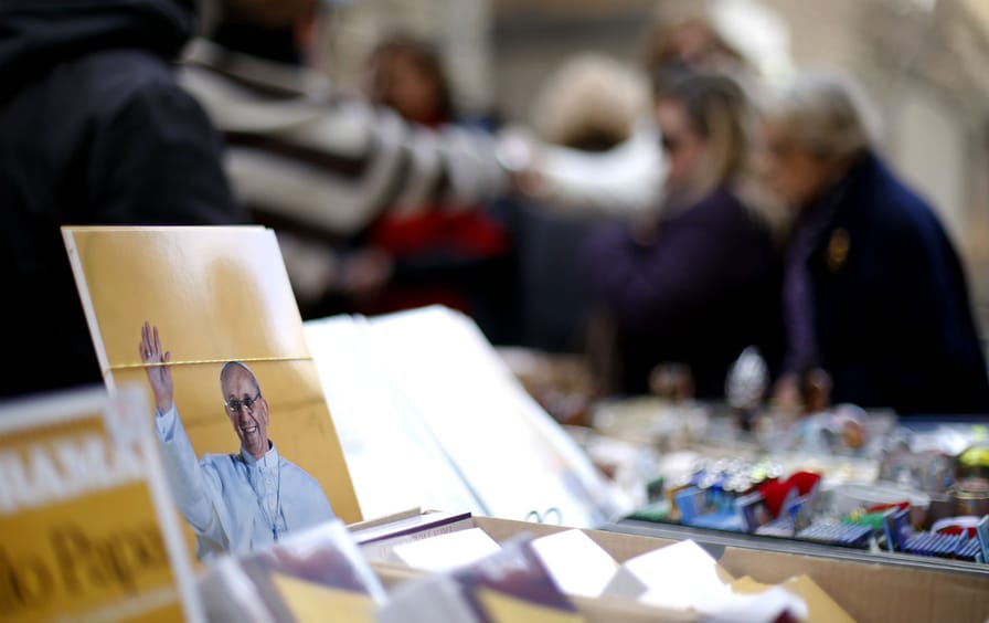 Prints of Pope Francis are seen in a newspaper kiosk near the Vatican.