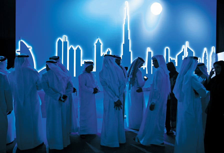 Emirati-attendees-wait-in-front-of-an-image-of-the-city’s-skyline-in-Dubai-on-March-5-2014