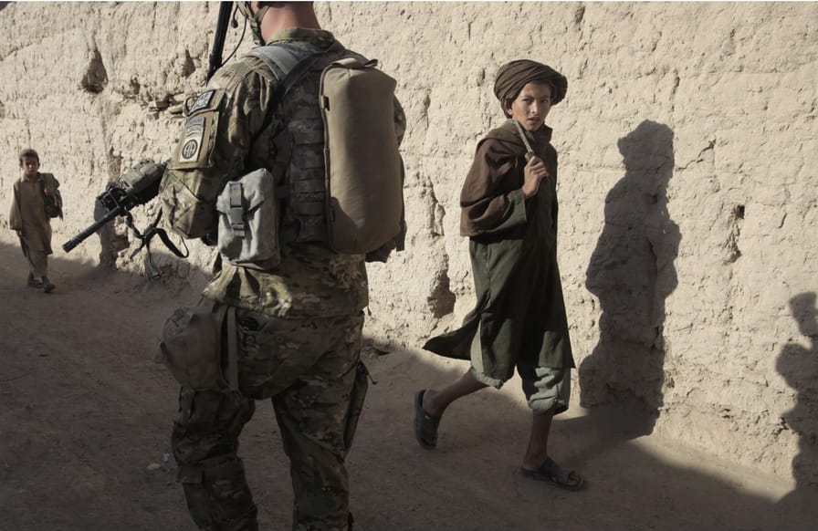 A-local-boy-looks-at-US-Army-soldiers-as-they-conduct-a-morning-patrol-through-the-village-of-Kowall-in-Arghandab-District-July-11-2010.-ReutersBob-Strong