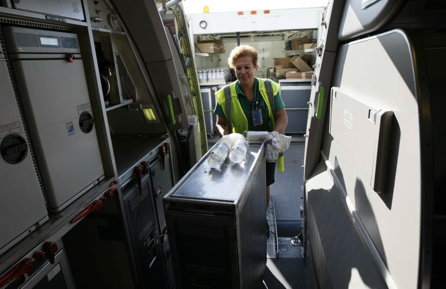 an-airport-catering-worker-loads-drinks-onto-a-plane