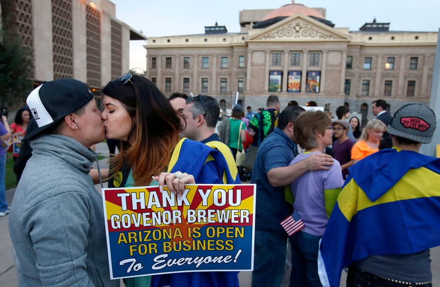 A-couple-kisses-after-learning-that-Arizona-Gov.-Jan-Brewer-announces-vetoed-SB1062-which-wouldve-granted-businesses-the-right-to-refuse-service-to-LGBTQ-people.-AP-PhotoRoss-D.-Franklin
