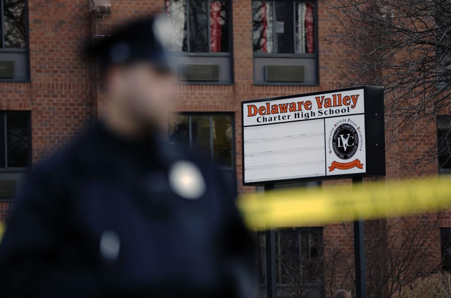 A-police-stands-by-caution-tape-at-the-Delaware-Valley-Charter-School-Friday-in-Philadelphia-where-two-students-were-shot-on-Jan.-17-2014.-AP-PhotoMatt-Rourke