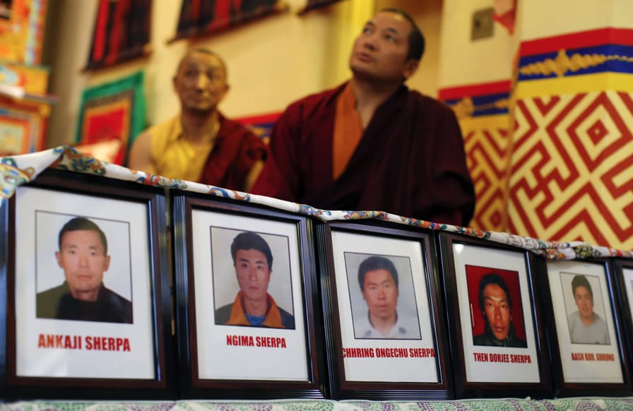 Pictures-of-Sherpa-members-are-displayed-while-Buddhist-monks-hold-a-prayer-service-for-those-killed