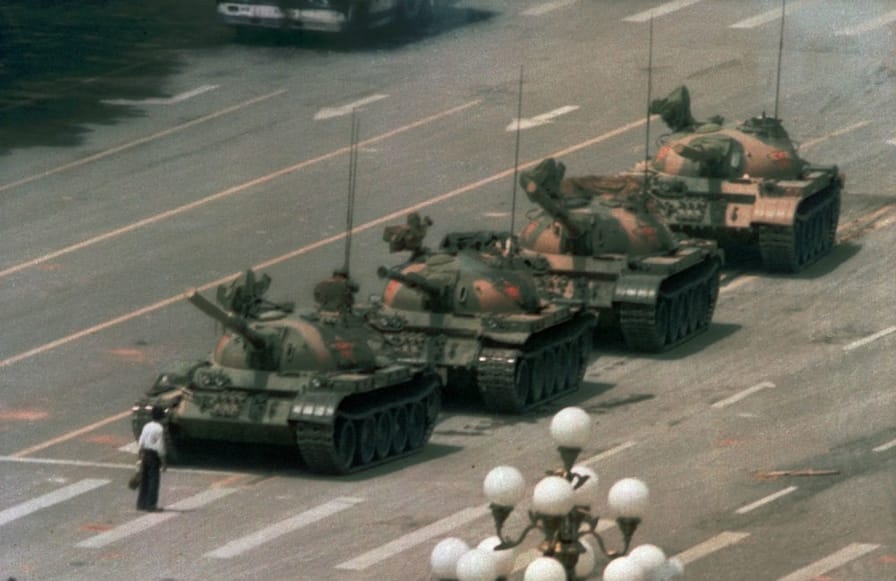 A-Chinese-man-stands-alone-to-block-a-line-of-tanks-heading-east-on-Beijings-Cangan-Blvd.-in-Tiananmen-Square-on-June-5-1989.-AP-PhotoJeff-Widener
