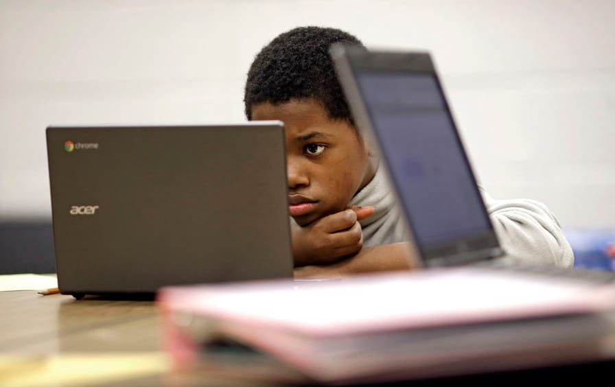 Student reads test questions on laptop