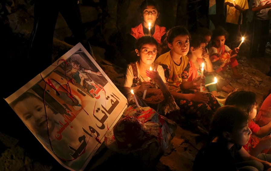 Palestinian children light candles during a rally to remember 18-month-old Palestinian baby Ali Dawabsheh who was killed after his family's house was set on fire in a suspected attack by Jewish extremists in Rafah in the southern Gaza Strip