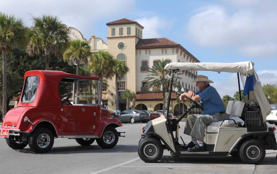 William LeBeau, 86, right, sits in his golf cart in The Villages.