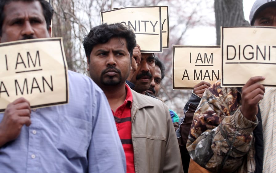 Indian workers take part in a protest outside the Indian Embassy in Washington, DC