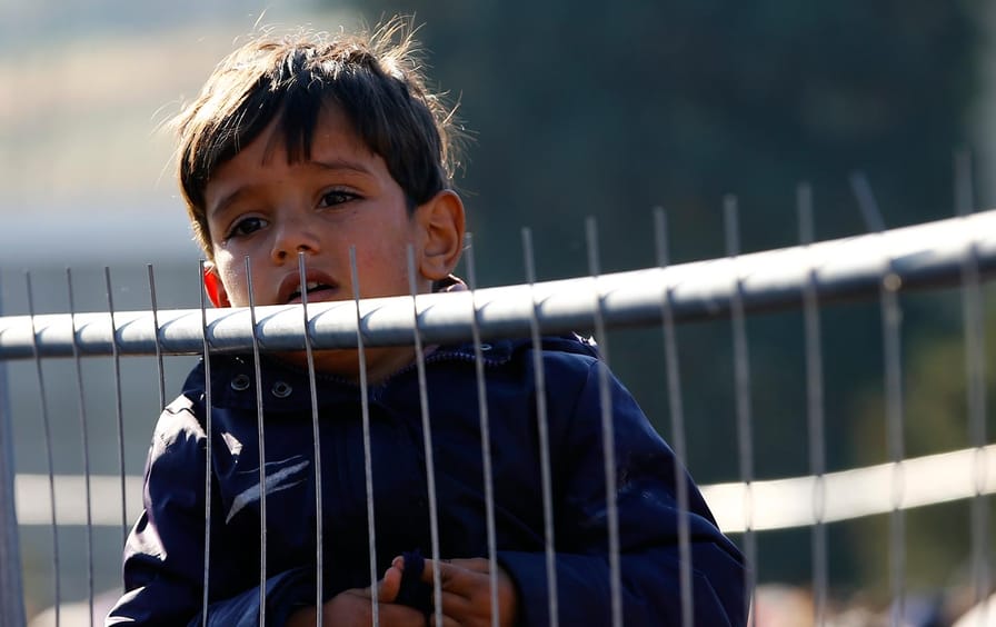 A migrant boy waits to cross the border from the village of Sentilj, Slovenia into Spielfeld in Austria, November 2, 2015.