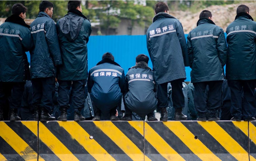 Workers of Sui Bao Security Transport Company strike for higher salaries, blocking a road in Guangzhou, China, February 11, 2014.