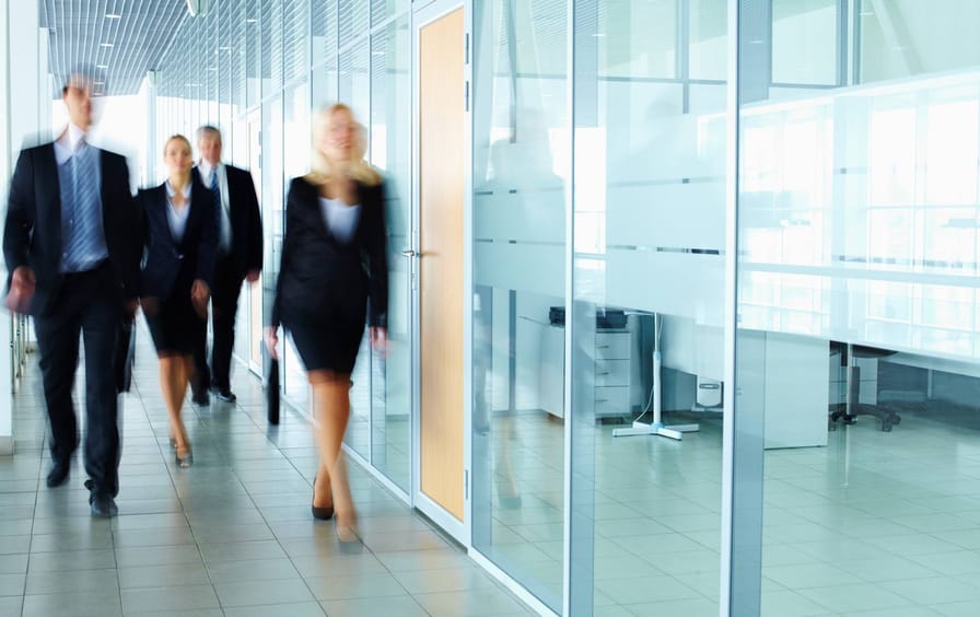 Several businesspeople walking in the corridor