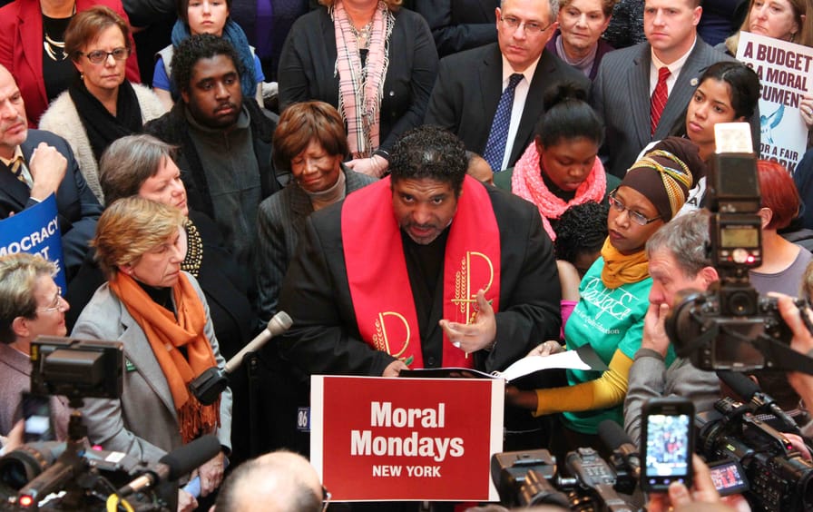National movement: Rev. William Barber (center) speaks to media at a Moral Monday rally in Albany, New York, in 2014.