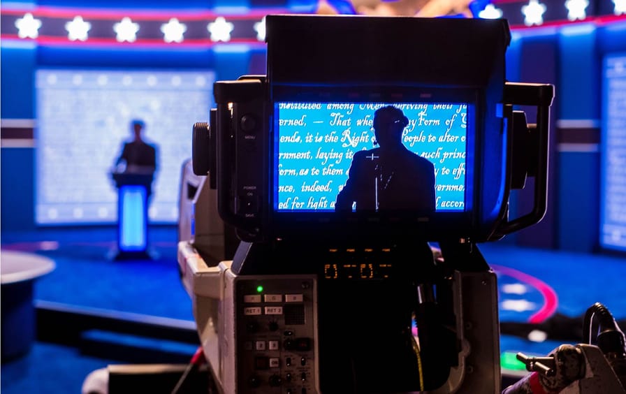 Person in monitor on debate stage