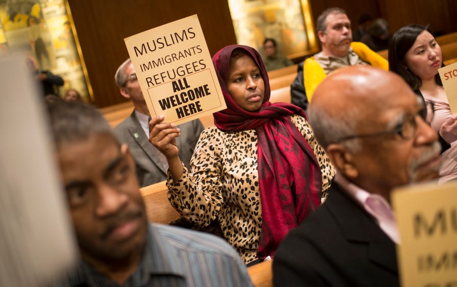 Farhio Khalif, an immigrant from Somalia, holds a sign