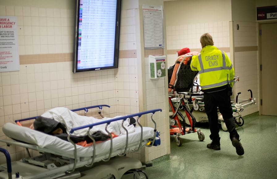 In Atlanta, January 24, 2014, an EMS worker wheels a patient through Grady Memorial Hospital’s emergency department.