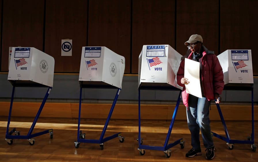 A woman exits the voting booth after filling out her ballot for the U.S presidential election at the James Weldon Johnson Community Center in the East Harlem neighbourhood of Manhattan, New York City