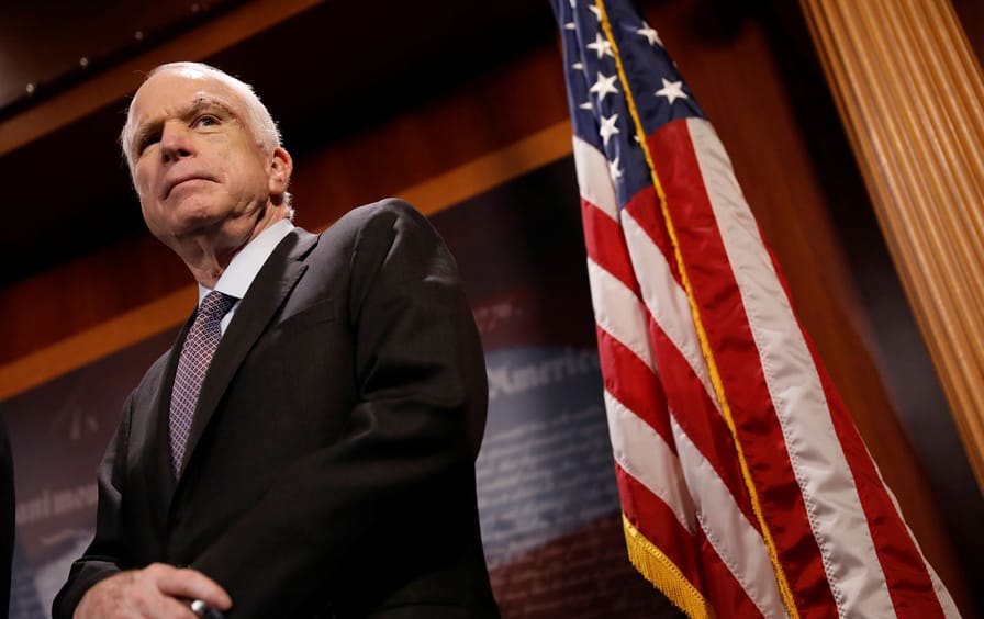 Senator John McCain looks on during a press conference