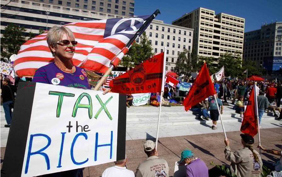 A woman holds a sign saying 