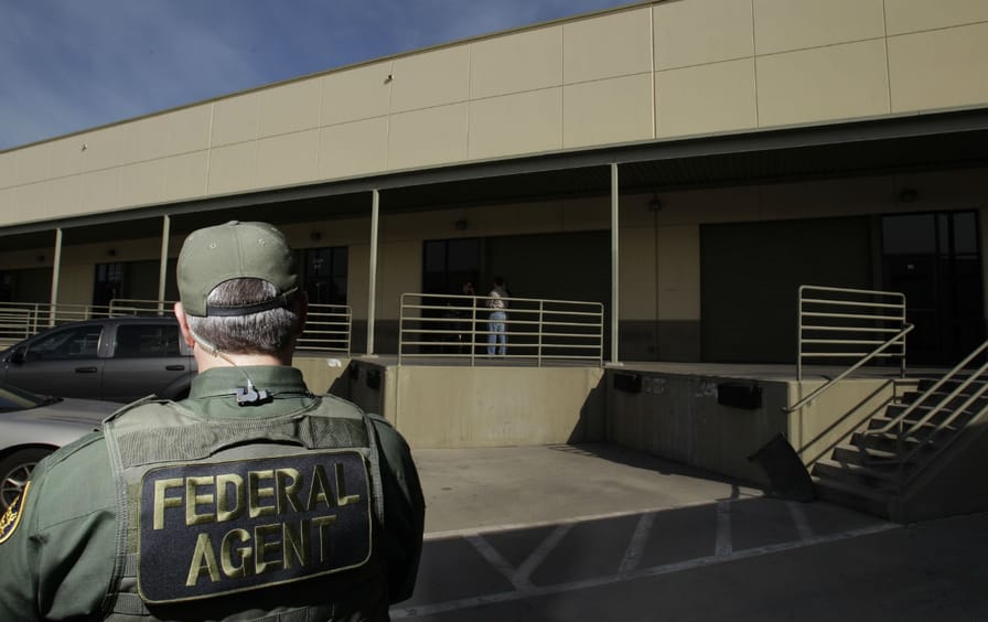 A federal agent stands outside of a building in San Diego, CA.