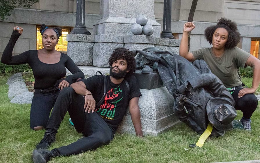 Activists pose after a Confederate statue is toppled in Durham, NC.