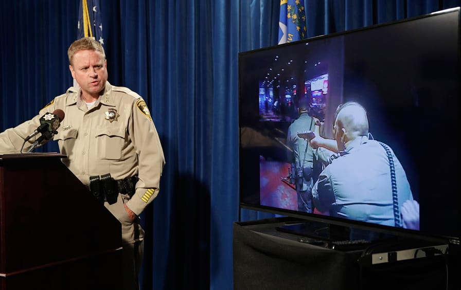 Las Vegas police Undersheriff Kevin McMahill watches body camera footage during a press conference