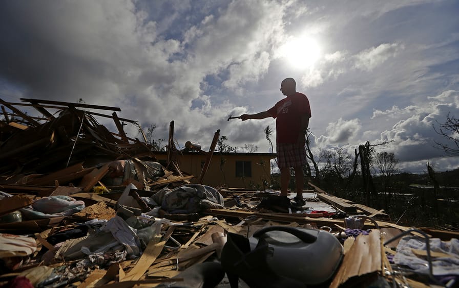 Jose Garcia Vicente holds a piece of plumbing he picked up, as he shows his destroyed home, in the aftermath of Hurricane Maria, in Aibonito, Puerto.