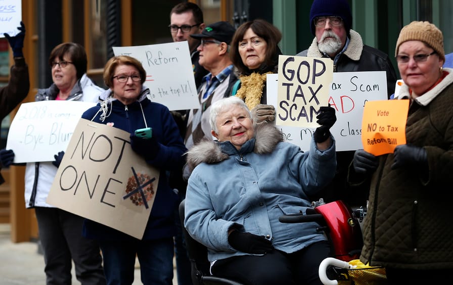 Marilyn Schroeder, center, gathers with other protesters to oppose the Republican tax plan.