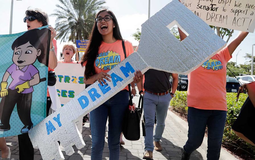 Maria Angelica Ramirez carries a large key reading 