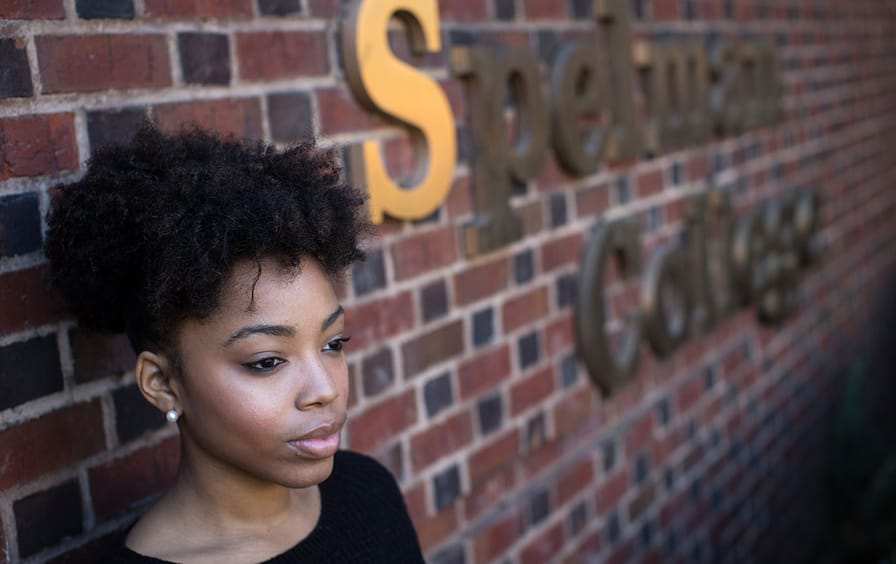 Female student stands in front of Spelman College sign