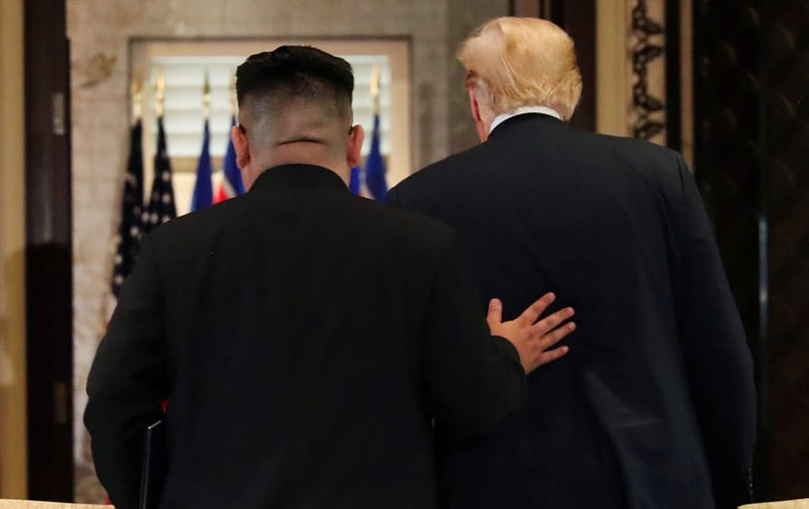 Trump Kim hand on back