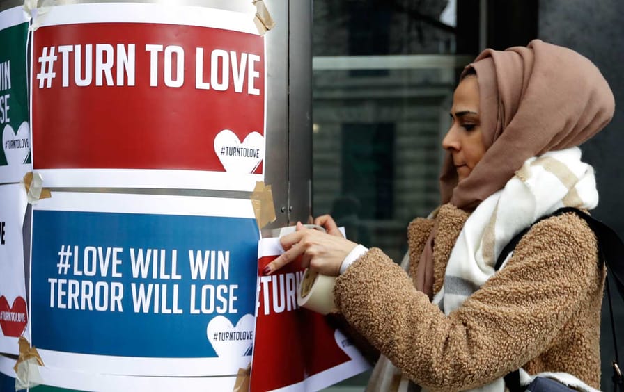 A demonstrator hangs banners from multi-faith group 'Turn to Love'