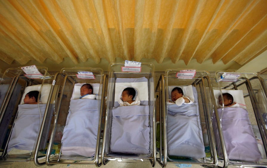 Babies lie in cots at a maternity ward in Singapore
