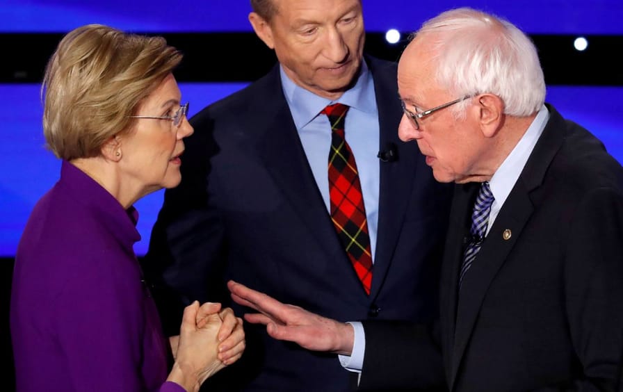 Senator Warren speaks with Senator Sanders.