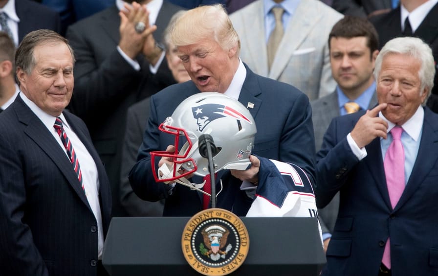 Trump holding a Patriots helmet