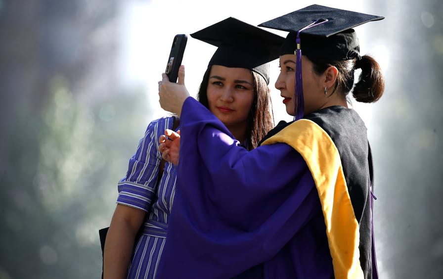 Two people pose for graduation photos