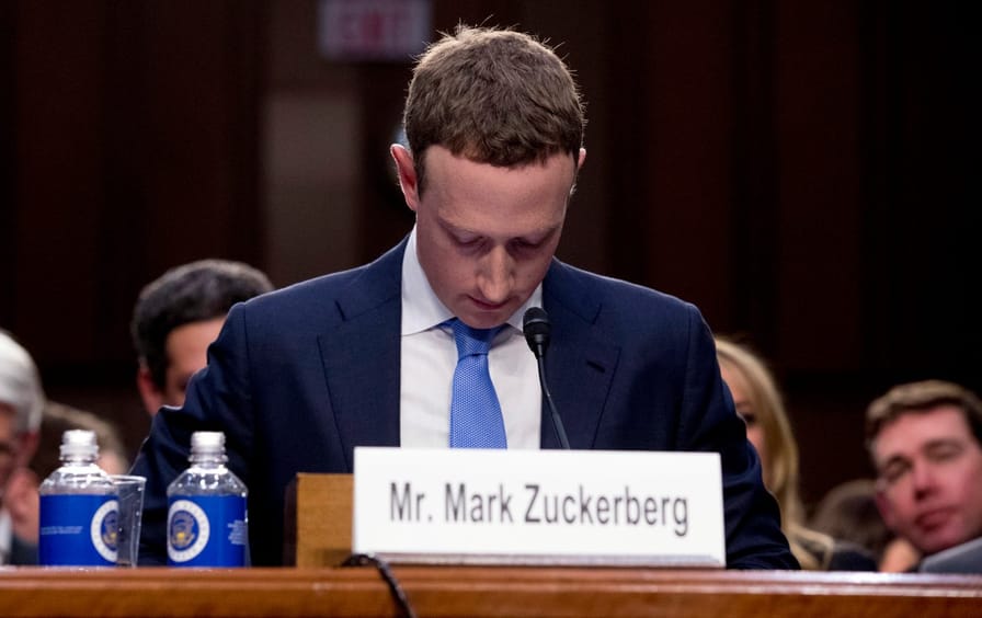 Mark Zuckerberg stares down at his lap