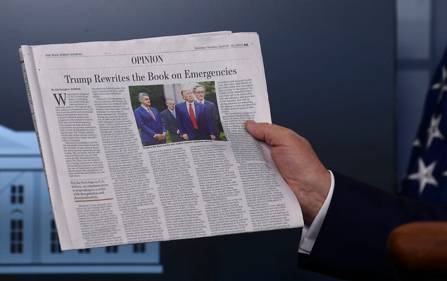 Donald Trump holds up WSJ Opinion section with an editorial titled 