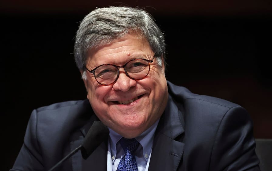 Bill Barr smiling in a suit