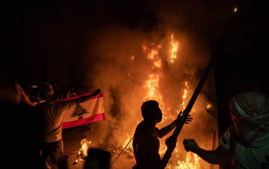 A silhouette of a protester in front of flames.