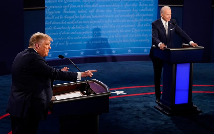Donald Trump pointing with Joe Biden in the background