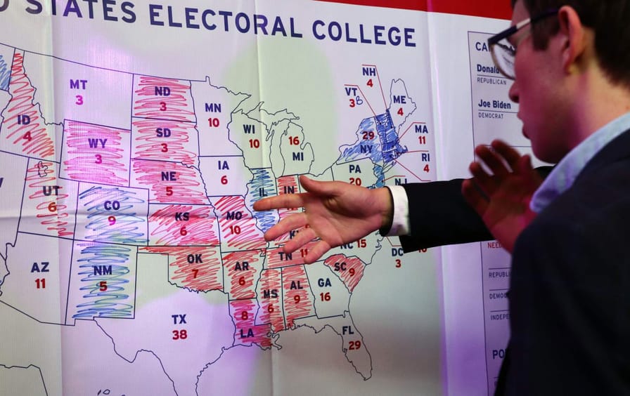Young man looks at electoral map colored in with markers