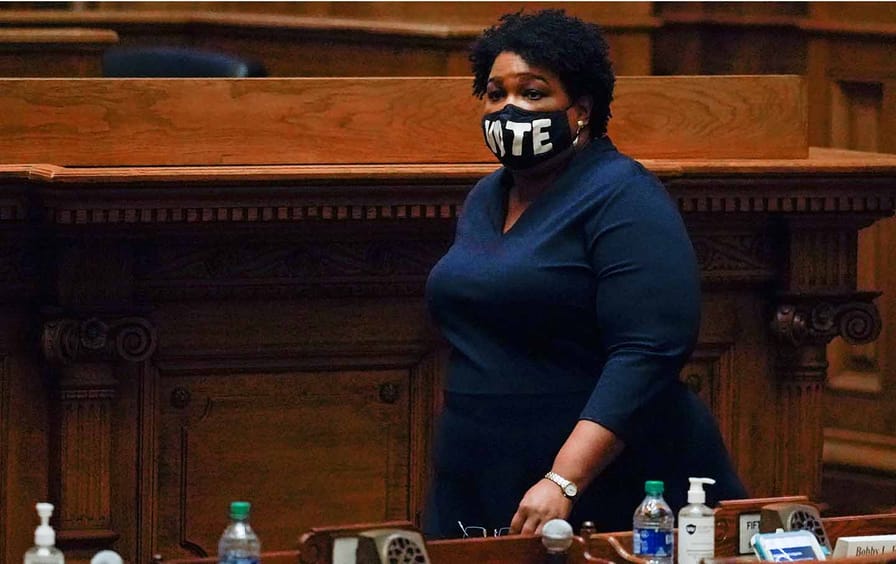 Democrat Stacey Abrams, walks on Senate floor before of members of Georgia's Electoral College cast their votes at the state Capitol, Monday, Dec. 14, 2020, in Atlanta. (AP Photo/John Bazemore, Pool)