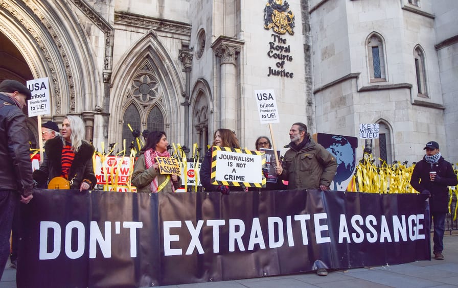 Protesters hold a 'Don't Extradite Assange' banner and