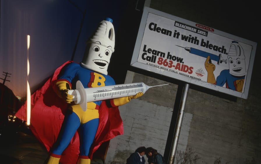 Bleachman Holding a Syringe on a City Street