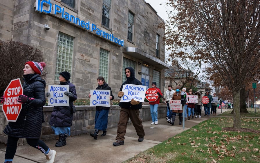 Anti-abortion protesters march past Planned Parenthood while