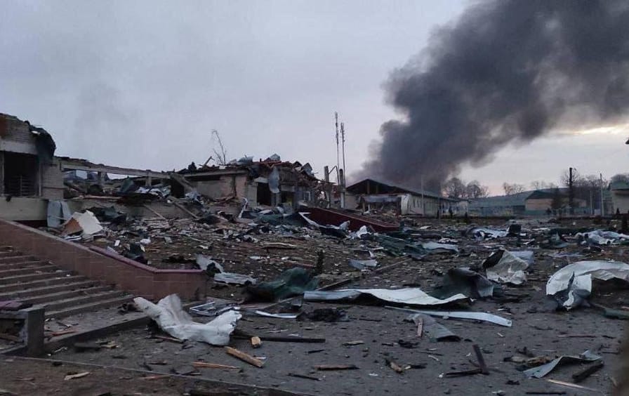 Rubble with smoke rising in the background